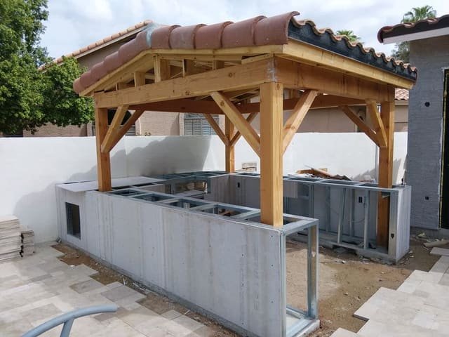 Covered patio with tile roof and outdoor kitchen under construction